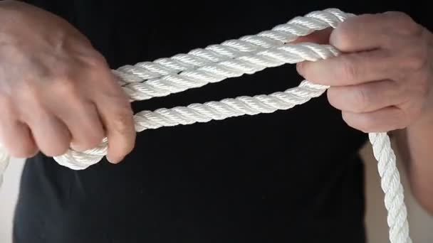 Een Man Banden Een Knoop Met Een Dik Touw — Stockvideo