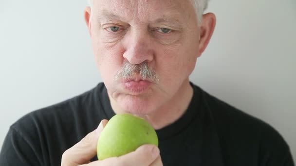 Hombre Mayor Comiendo Una Pequeña Manzana Verde — Vídeo de stock