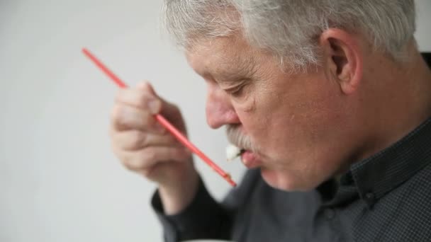 先輩男性が箸でエビ寿司を食べる — ストック動画