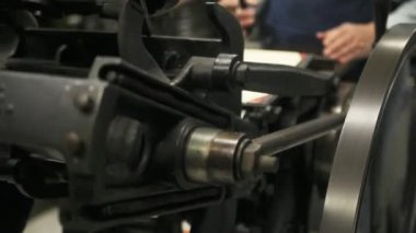 Bir adam antika bir letterpress makinesi işletiyor.