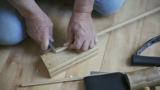 一个男人使用箱形切割器切割和修剪一块底板 — 图库视频影像