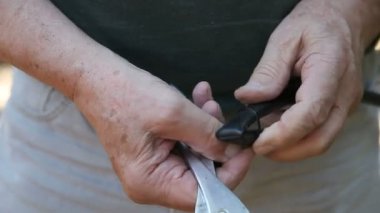 Bir adam kauçuk boru bir bölümünü bükmek için pliers kullanır