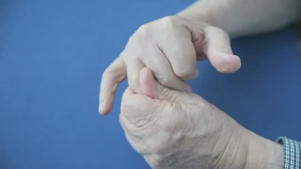 年配の男は指に感情を取り戻そうとする — ストック動画