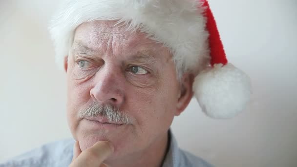Starší Muž Santa Klobouku Vypadá Zamyšleně Zatímco Třel Bradu — Stock video