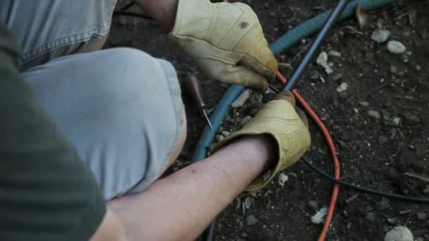 一名男子在后院的Diy发射器灌溉系统工作 — 图库视频影像