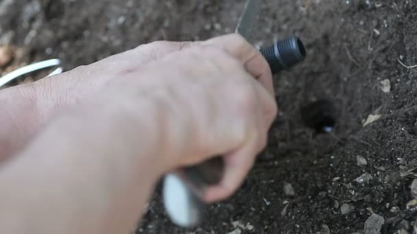 Mann Schneidet Mit Messer Teil Der Sprinkleranlage — Stockvideo