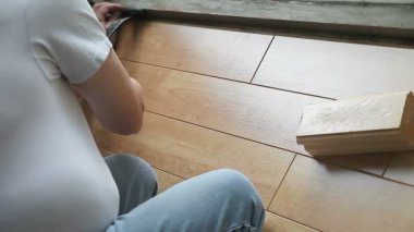 Adam yerde laminat parke kilitlemek için çeşitli araçlar kullanır