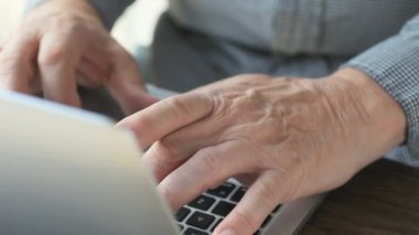 Dizüstü bilgisayar klavyesini kullanan kıdemli