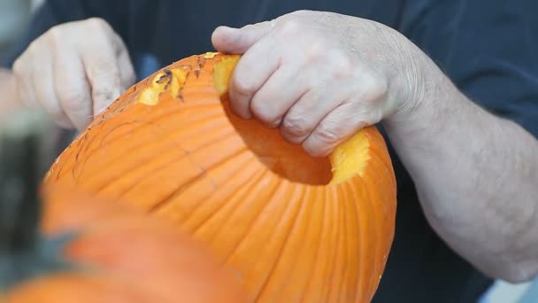 Ein Mann Benutzt Ein Scharfes Schnitzwerkzeug Auf Seinem Halloween Kürbisgesicht — Stockvideo