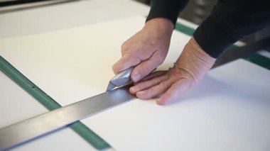 Adam aynı anda kağıt birkaç yaprak kesmek için maket bıçağı kullanarak