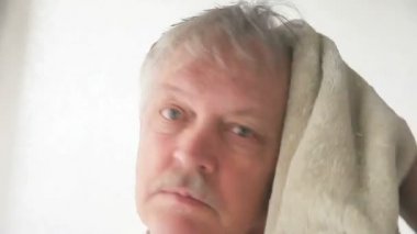 Yaşlı bir adam saçlarını havlu