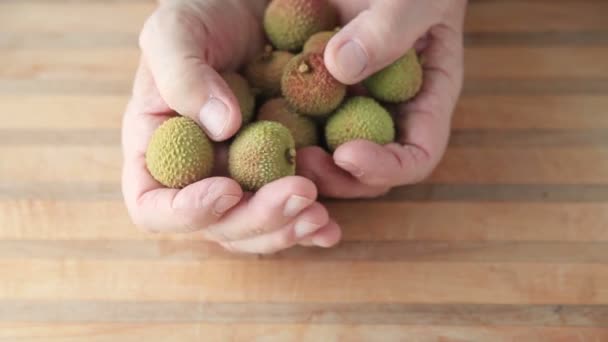 Een Man Kijkt Verse Lychee Fruit Zijn Handen — Stockvideo