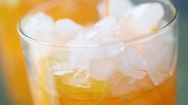 Buzlu bir bardağa portakallı soda dökmek