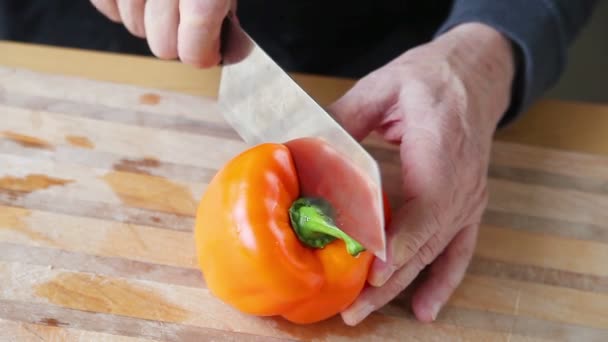 Ein Älterer Mann Ringt Darum Eine Paprika Zwei Hälften Schneiden — Stockvideo