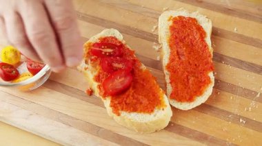 Bir adam bruschetta için kiraz domates yarım ekler