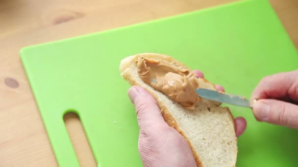 Bărbat Mai Vârstă Pune Unt Arahide Felie Pâine Peste Placă — Videoclip de stoc