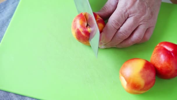 Hombre Corta Una Nectarina Fresca Una Tabla Cortar Verde Con — Vídeos de Stock