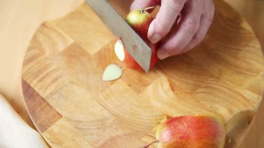 Bir adam renkli bir armut kopya alanı ile ince dilimler halinde keser