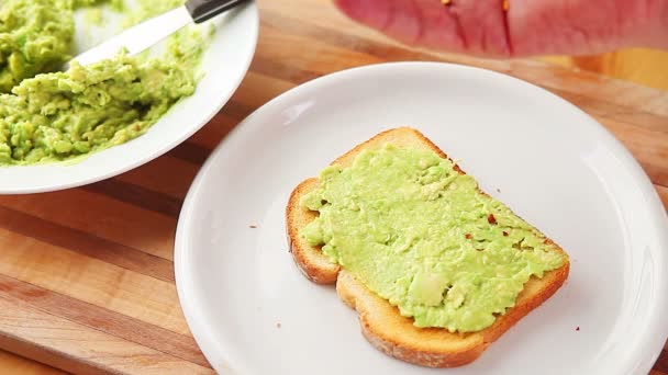 Man Strössel Kryddig Smaksättning Bit Avokado Toast — Stockvideo