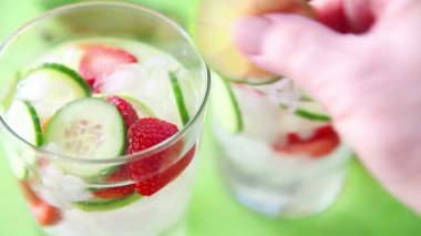 Soğuk çilek ve salatalık aromalı su bardaktaze limon dilimleri koyarak