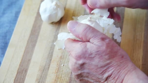 Man Rubs Papery Layers Garlic Bulb — Stock Video