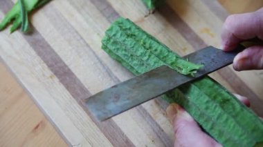 Bir adam dikkatle dekoratif bir görünüm için yeşil biraz bırakarak, bir sırtlı kabak soyuyor