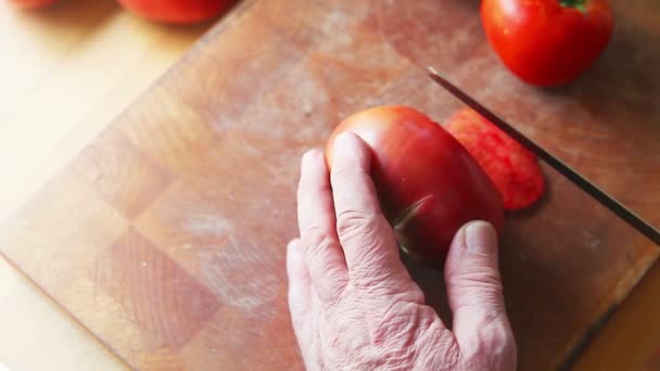 Starszy Mężczyzna Przecina Duży Pomidor Plasterki Drewno Deska Krojenia — Wideo stockowe