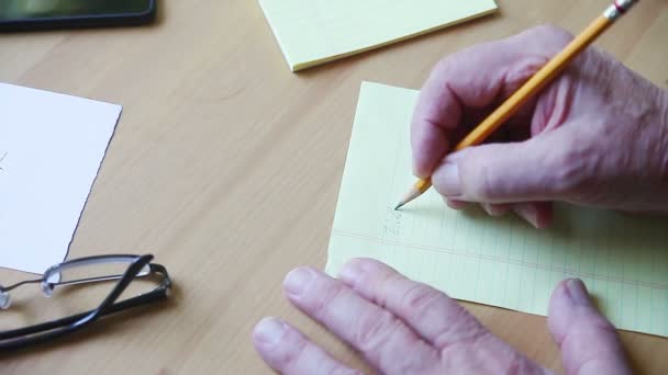 Older Man Makes List Using Pencil — Stock Video