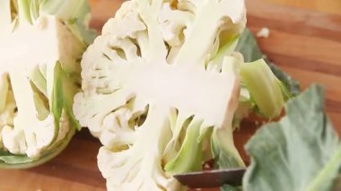 Bir kadın taze karnabaharı parçalar.