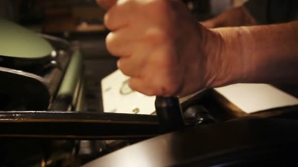 彼がアンティーク印刷機を操作するようにフライホイールハンドルを握ります — ストック動画