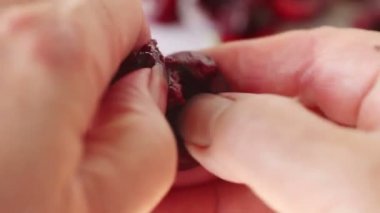 Parmaklarıyla taze kiraz çukurlarını kaldıran bir kadının yakın çekim