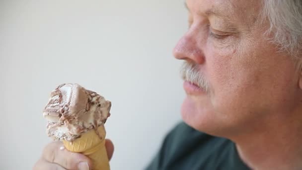 年配の男性はファッジリップルアイスクリームを楽しんでいます — ストック動画