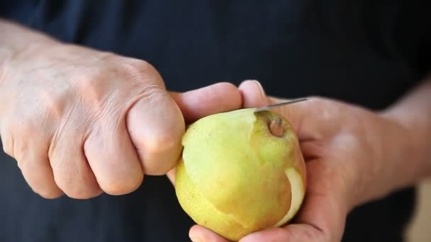 年配の男性は 新鮮な梨から皮を取り除きます — ストック動画