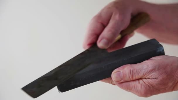 一个年长的男人用磨刀刀磨一把旧菜刀 — 图库视频影像
