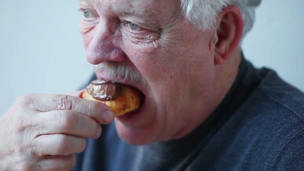 Пожилой Мужчина Наслаждается Мини Круассаном Покрытым Шоколадом — стоковое видео