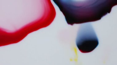 Kırmızı ve koyu mavi boya iner ve dağılmadan önce kendilerine karşı basın