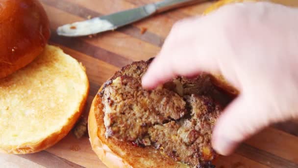 Woman Puts Meatloaf Pickles Lettuce Tomato Toasted Brioche Buns — Stock Video