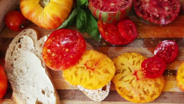 Kvinna Gör Smörgås Med Saftiga Gula Och Röda Heirloom Tomater — Stockvideo