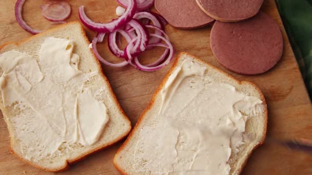 Una Mujer Pone Mayonesa Rodajas Braunschweiger Cebollas Rojas Pan Blanco — Vídeo de stock