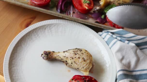 Uma Mulher Usa Pinças Para Servir Pernas Frango Tomates Roma — Vídeo de Stock