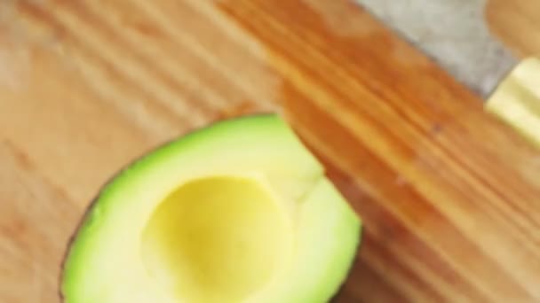 Met Behulp Van Een Keukenmes Een Vrouw Verwijdert Een Avocado — Stockvideo