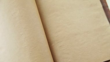 Bir kadın antika el yapımı bir kitabın sayfalarını çeviriyor.