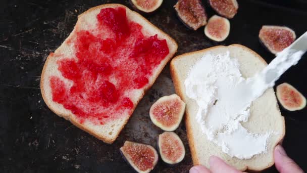 Woman Spreads Cream Cheese Places Fresh Fig Halves White Bread — Stock Video