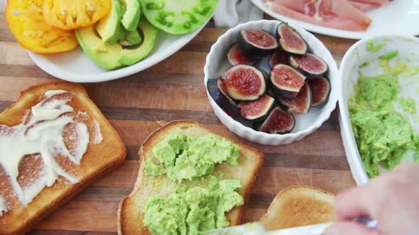 Una Donna Aggiunge Purè Avocado Fichi Freschi Prosciutto Tostato — Video Stock