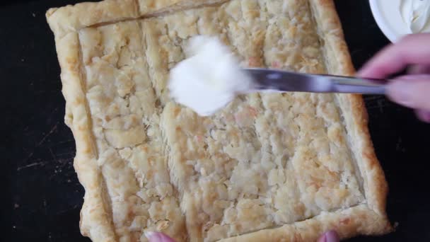 一个女人把软奶酪放在煮熟的膨化糕点片上 — 图库视频影像