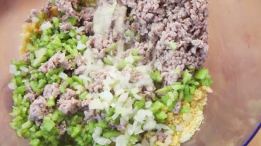 Bir kadın Şükran doldurma yapmak için mısır ekmeği, sosis, soğan ve kereviz karıştırır