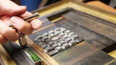 Bir letterpress yazıcı metal türü harfler tutan kovalamaca sıkılaştırmak için bir quoin anahtarı kullanır