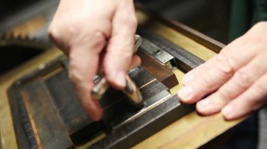 Bir letterpress yazıcı metal türü harfler tutan kovalamaca sıkılaştırmak için bir quoin anahtarı kullanır