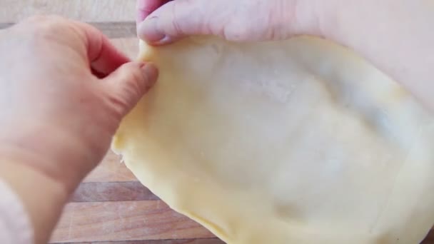 女性は風味豊かなパイの上に焼かれていない地殻を置き それを圧着する — ストック動画