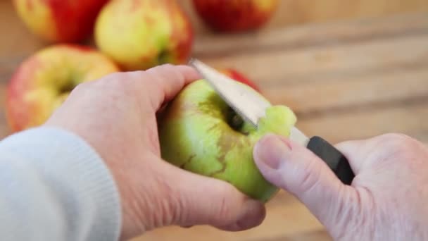 一个女人从一个小的绿色苹果上取下果皮 — 图库视频影像